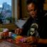 Person organizing weekly pillbox at home