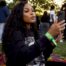 Woman broadcasting advocacy rally on smartphone outdoors