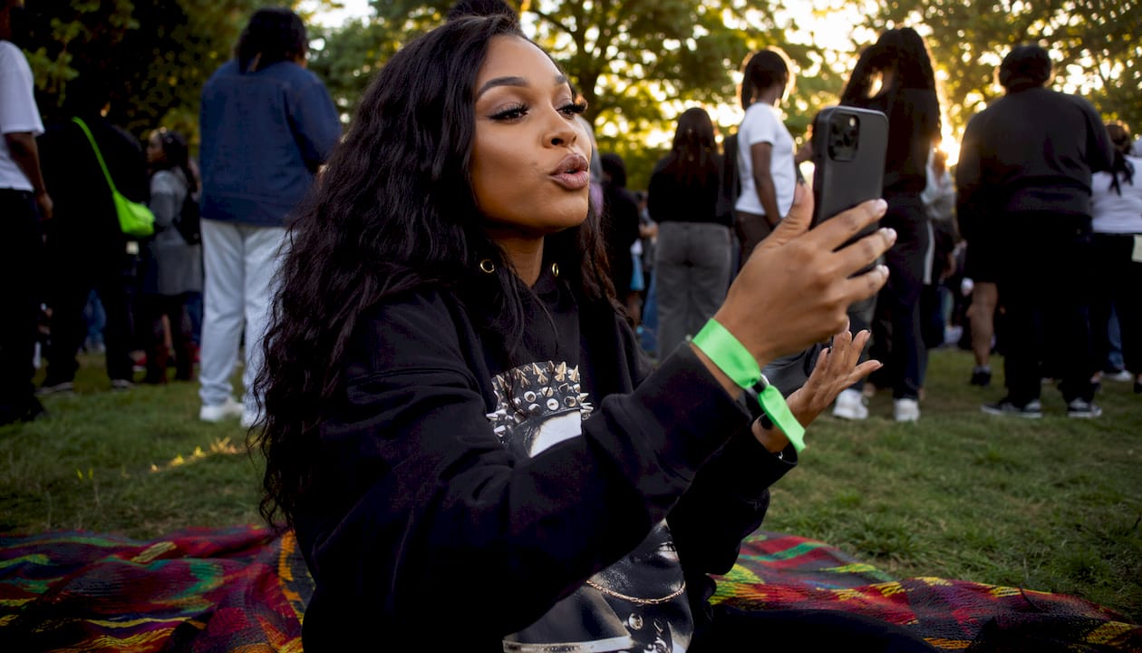Woman broadcasting advocacy rally on smartphone outdoors