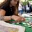 Volunteer arranging enamel buttons on event table