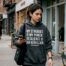 Young woman in advocacy sweatshirt on city sidewalk