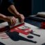 Hands screen-printing an advocacy fabric panel