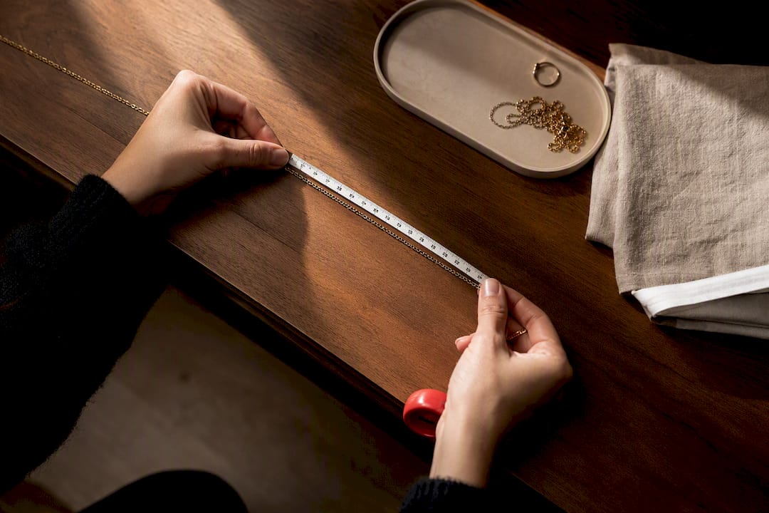 Hands measuring necklace chain length