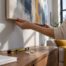 Hands aligning canvas on wall