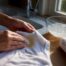 Hands treating yellow underarm shirt stain