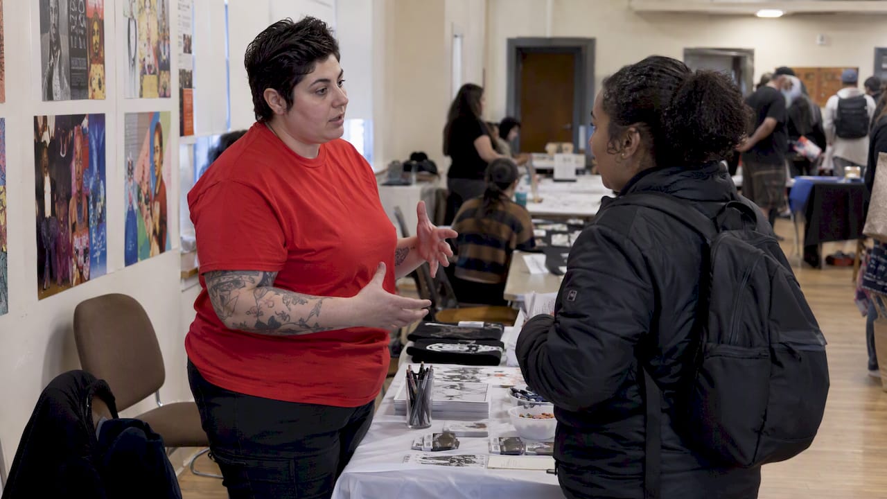 Advocate talking with an attendee at a booth