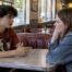 Teen friends having a quiet conversation in a diner