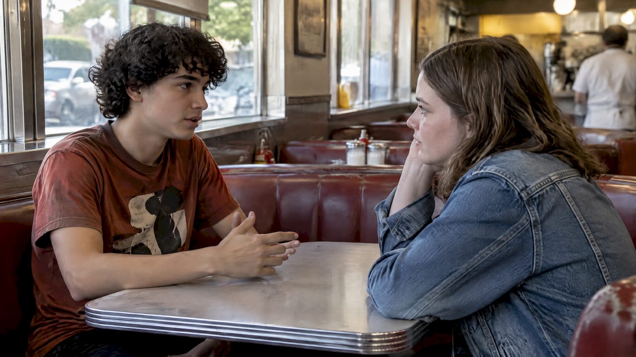 Teen friends having a quiet conversation in a diner